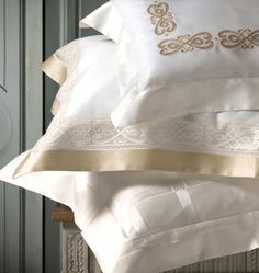 a stack of white and gold pillows on top of each other