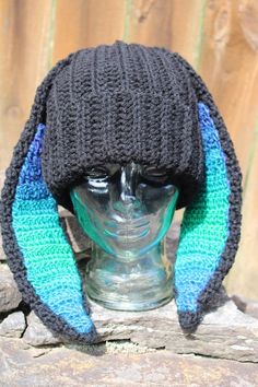 a knitted hat on top of a glass head