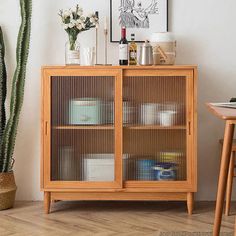 a wooden cabinet sitting next to a potted plant