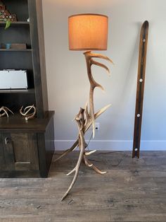 a lamp that is on top of a wooden floor next to a book shelf and desk