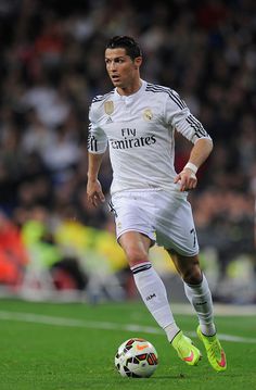 a soccer player is running with the ball in his hand and an ad for real madrid