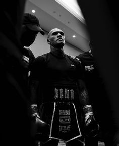 a man standing next to another man wearing boxing gloves