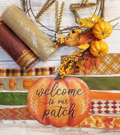 a welcome to our patch pumpkin sitting next to fall decorations