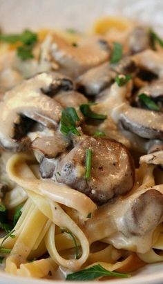 a white plate topped with pasta covered in mushrooms