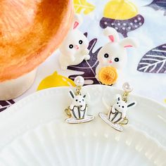 two small white rabbits sitting on top of a plate