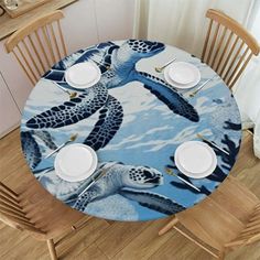 the table is set with plates and place settings for two sea turtle themed dinnerware