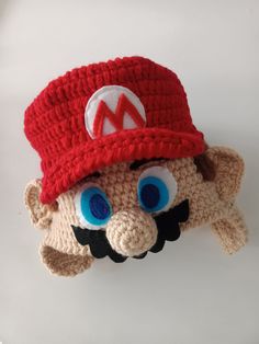 a crocheted mario hat with big blue eyes