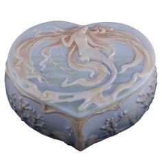 a blue and white heart shaped box with a mermaid in the middle on it's side