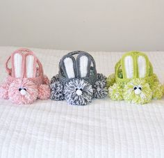 four small crocheted purses sitting on top of a white bedspread