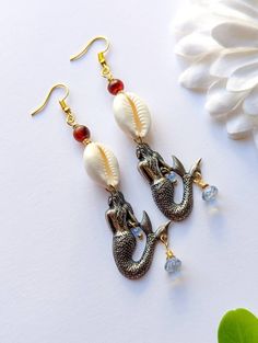 These  feature: ~ White cowrie shells ~ Vintage Carnelian beads ~ Teardrop blue quartz beads ~ faceted blue glass crystals ~ 1.4 x 1 inch sterling silver plated (over brass) Mermaid charms  ~ Gold plated ear wire hooks ~ They are 3 inches long.  Thanks for shopping with JewelryByOri! ~ Shop more Cowrie Jewelry from JBO here: https://www.etsy.com/shop/JewelryByOri?ref=seller-platform-mcnav&search_query=Cowrie Nickel Free Bohemian Shell Jewelry, Beach Dangle Beads Jewelry, Bohemian Nickel-free Shell Jewelry, Bohemian Shell Beaded Earrings, Beach Drop Earrings With Natural Stones, Nickel Free Shell Bohemian Earrings, Bohemian Shell Earrings Nickel Free, Bohemian Nickel-free Shell Earrings, Beaded Dangle Beach Jewelry