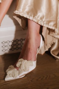 the bride's shoes are adorned with pearls and bowknots on her wedding day