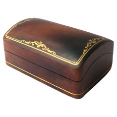 a wooden box with gold trimmings on it