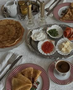 a table topped with plates and cups filled with food