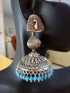 "These are an exquisite pair of jhumkas very ornate and the peacock posts add elegance! Blue beads complement very well! Let me know if you want all silver beads or differnt crystals- happy to customize. All custom requests will be extra! These jhumkas are on the large side but not heavy at all! These are famous in Jaipur, Rajasthan and all over India, wear this with a tunic top on jeans or shorts, simply out of this world. Wear these to your favorite Indian Restaurant Total length from top of the ear wire 2.5\".  WIdth-1.8\". Metal - oxidized Sterling Silver. Please feel free to ask me for more pictures or questions. Thank You for Shopping Jhumkas they are Ancient, Elegant, Opulent and Regal!" Elegant Peacock Design Jhumkas For Navratri, Bohemian Peacock Design Danglers For Diwali, Bohemian Peacock Design Danglers For Festivals, Bohemian Peacock Danglers For Diwali, Bohemian Peacock Danglers For Festivals, Blue Tilla Jhumkas For Festivals, Bohemian Peacock Design Jhumkas As Gift, Bohemian Peacock Design Jhumkas For Gift, Bohemian Chandbalis With Peacock Design For Festivals