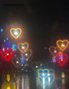 many lights are shining on the street in the night time and heart shaped shapes can be seen here