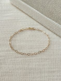 "Hearts are melting for this dainty yet durable mini heart chain bracelet! 💛 This unique chain is sensitive skin and water safe, and is made to live your life in! Wear this minimal piece to brunch, or on a date... this simple heart chain looks lovely anywhere you take it! Details: * 3.5mm 14K Gold Filled heart chain * Dainty 14K Gold Filled spring clasp * 14/20 gf stamp for authenticity * Choose your length (each bracelet comes with a .5\" extender chain for adjustable sizing.) * Made with all Simple Chain Bracelet, Bracelets Simple For Women, Minimalist Gold Bracelet, Heart Chain Bracelet, Gold Bracelet Simple, Minimal Bracelet, Bracelet Love, Bracelet Minimalist, Heart Chain