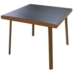 a wooden table with a black top on a white background in front of a white backdrop