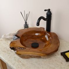 a wooden bowl sink sitting on top of a counter next to a faucet