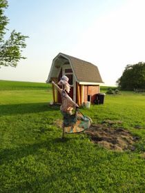 a woman digging dirt in front of a shed