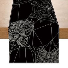 a black and white spider web table runner