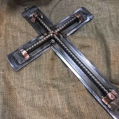 a metal cross sitting on top of a brown cloth