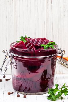 beet soup in a glass jar with garnishes on the side