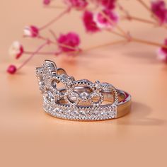 Delicate and romantic, this crown-shaped ring will utterly delight the queen of your heart. Fashioned in sleek sterling silver, this ring features open hearts and sparkling stones. Twinkling round stones, meaningful hearts and milgrain detailing complete this lovely style. A regal choice for your princess, this ring creates a romantic look. Carat Weight: 0.762 ctStone Size: 1.1,1.25,1.5 mmStone Type: Jeulia® StoneNumber of Stones: 31 Stone Color: Diamond WhiteStone Shape: RoundWeight: 5.63 gWidt Luxury Anniversary Ring With Crown Design, Luxury Anniversary Rings With Crown Design, Luxury Crown Design Rings For Anniversary, Elegant Rings With Crown Design, Elegant Round Crown Anniversary Ring, Elegant Wedding Rings With Round Crown, Elegant Silver Ring With Round Crown, Elegant Crown Design Cubic Zirconia Rings, Elegant Crown-shaped Diamond Ring For Anniversary