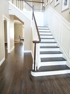 there is a staircase leading up to the second floor in this house with wood floors and white railings