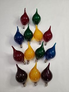 there are many different colored lights in the shape of pears on this white surface