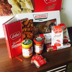 a variety of food items are displayed on a wooden countertop in front of a painting