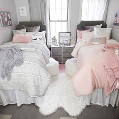 two beds with pink and grey comforters in a bedroom next to a window,