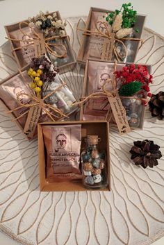 several small bottles with flowers in them on a table next to pine cones and twine