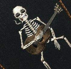 a skeleton playing a guitar on a black background