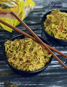 two black bowls filled with noodles and chopsticks