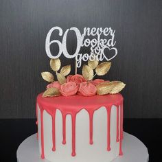 a red and white cake with gold leaves on top that says 60 never looked so good