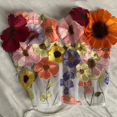 several different colored flowers on a white sheet