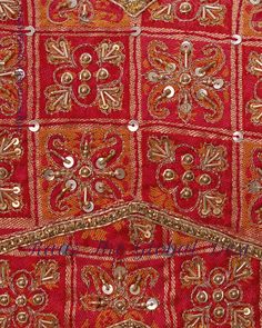 an embroidered red cloth with gold and silver beads on it's edges, in the shape of a flower