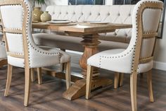 a dining room table with white chairs around it