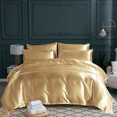 a bed with gold sheets and pillows in a room