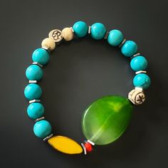 The Green Agate Summer Vibe Bracelet is a stunning accessory that exudes a sense of energy and vitality. The Green Agate stone is said to promote balance and harmony, while the other stones and beads are thought to have their own unique energy properties as well.The bracelet also features a vibrant yellow African bead, which is said to symbolize happiness and prosperity. Together, these elements create a beautiful and vibrant piece that is perfect for adding a touch of color to any summer outfit Jade Bracelets With Natural Stones For Meditation, Jade Stretch Bracelet For Meditation With Natural Stones, Spiritual Healing Bracelets With Oval Beads, Jade Stretch Bracelet With Natural Stones For Meditation, Bohemian Blue Agate Bracelets, Handmade Jade Bracelets For Meditation, Agate Bracelets With Polished Beads For Meditation, Handmade Bohemian Jade Stretch Bracelet, Turquoise Jade Healing Bracelets