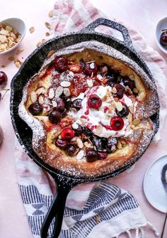 a skillet filled with fruit and nuts on top of a table