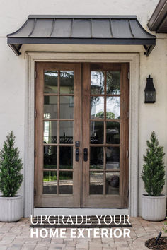 the front door to a home with two potted plants