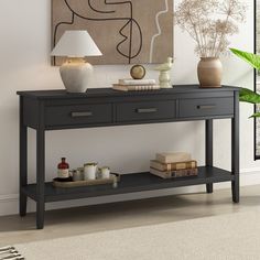 a console table with two vases and pictures on the wall