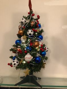 a christmas tree decorated with soccer balls and ornaments