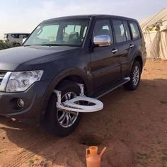 an suv parked in the desert with its wheel being lifted off it's tire