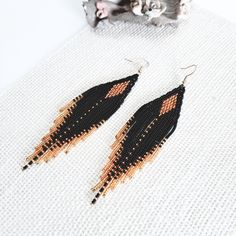 ❤️ Look gorgeous in these long beaded fringe earrings made in classic colors of black and gold. Made with opaque black and sparkly golden seed beads to give it a unique look. Wear it with a matching dress or mix and match with your favorite outfit.   Earring Length: 5 inches ❤️ Handmade with great care and attention to detail using high quality czech seed beads and woven in strong nylon beading thread. The earrings are attached with gold plated ear wire for ease of wear. Each bead is picked up using a needle and woven to create a distinct chevron pattern. ❤️ Buy for yourself or it makes for a great gift for birthday, anniversary or any other occasion. Black Tassel Earrings With Colorful Beads For Gift, Black Tassel Drop Earrings With Colorful Beads, Black Beaded Fringe Earrings With Round Beads, Black Beaded Earrings With Round Beads And Fringe, Black Beaded Tassel Earrings With Round Beads, Black Beaded Fringe Tassel Earrings As Gift, Black Beaded Earrings With Tassels, Black Beaded Drop Tassel Earrings, Black Beaded Long Drop Earrings