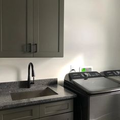 a washer and dryer sitting in a kitchen next to a counter with a sink