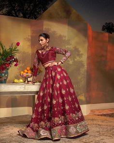 Maroon Pakistani Bridal Dress in Lehenga Choli Style is an epitome of royalty and grace that gives you your desired dreamy appearance on the big day. Resham, embroidery, zari, and floral designs make this stunning Bridal Lehenga Choli your foremost priority for the wedding. Choli: Beautiful choli in the graceful maroon shade is an exquisite choice to pair with Lehenga. This choli is simple and the sleeves are hand-embellished with lavish details of embroidery, zari, kundan and dabka kora. Floral Raw Silk Gown With Pallu For Wedding, Raw Silk Wedding Gown With Pallu, Wedding Lehenga With Dabka Work In Traditional Drape, Raw Silk Gown For Eid And Traditional Ceremonies, Embroidered Brocade Choli For Reception, Traditional Saree Gown In Art Silk, Elegant Dola Silk Anarkali Set For Ceremonies, Raw Silk Gown With Dupatta For Traditional Ceremonies, Elegant Dola Silk Anarkali For Traditional Ceremonies