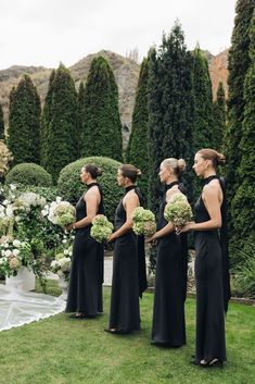 a group of women standing next to each other on top of a lush green field