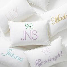 six embroidered pillows with names on them